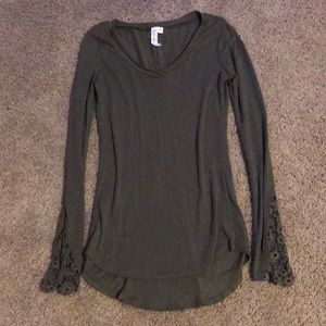 Green long sleeve shirt with lace accent around the arms, has cute back design.